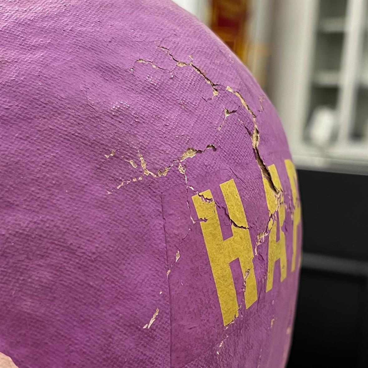 Detail image of cracks in the paper mache covering of the Easter egg.