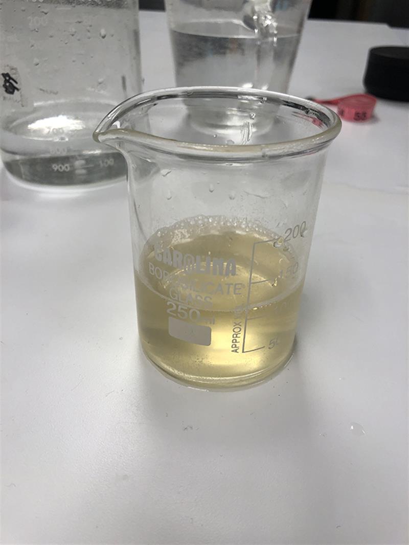 A beaker half filled with dirty water.