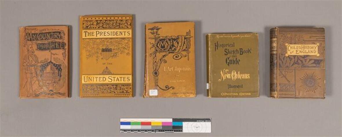 Five books with yellowed covers. The green decoration and lettering has changed to black as the books aged.
