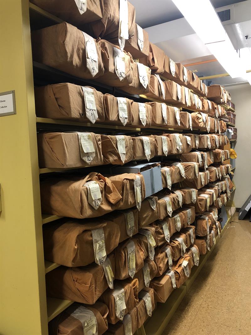 Stacks of brown paper-wrapped packages on library shelves.
