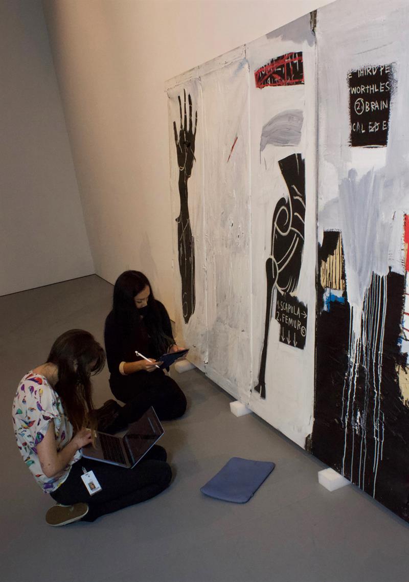 WUDPAC students examining and making notes about a painting.