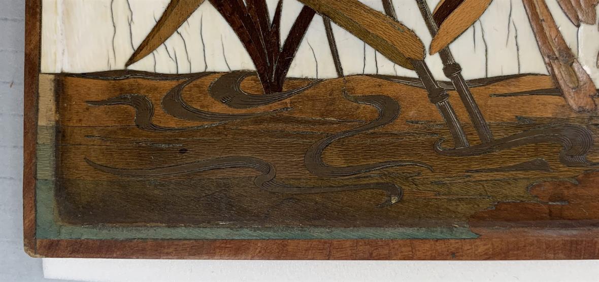 Detail of the marquetry panel, showing green-colored inlay.