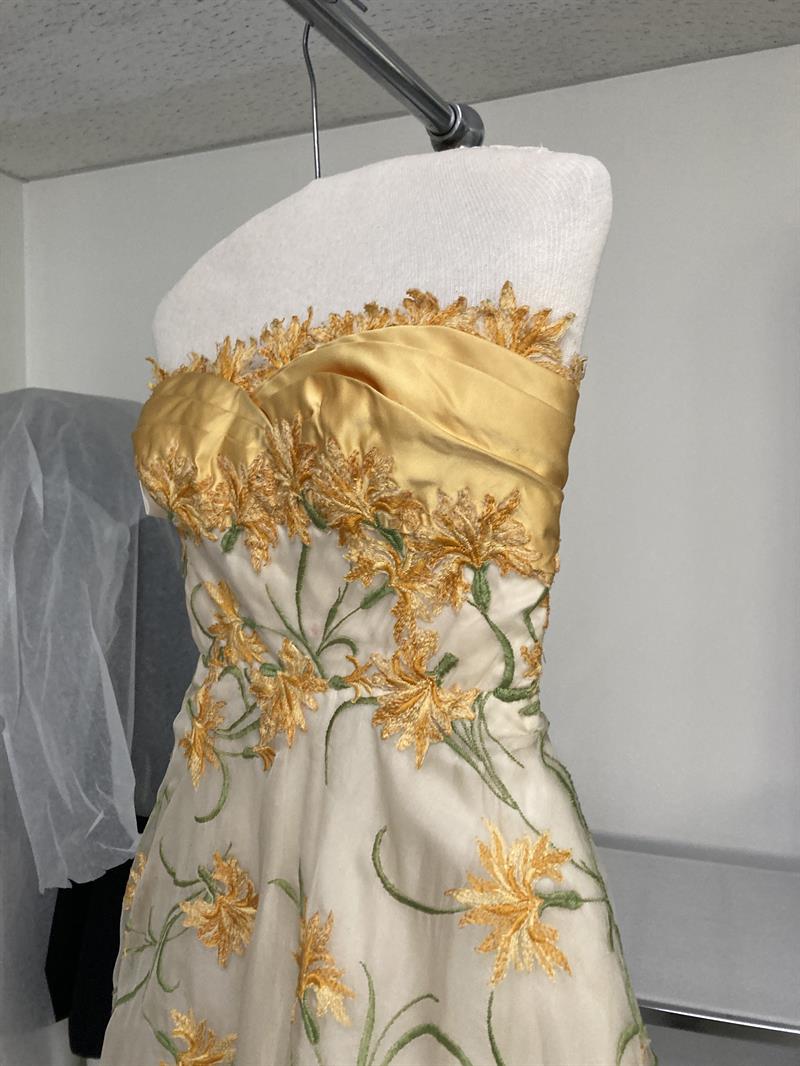 A white and gold-embroidered dress, on a mannequin.