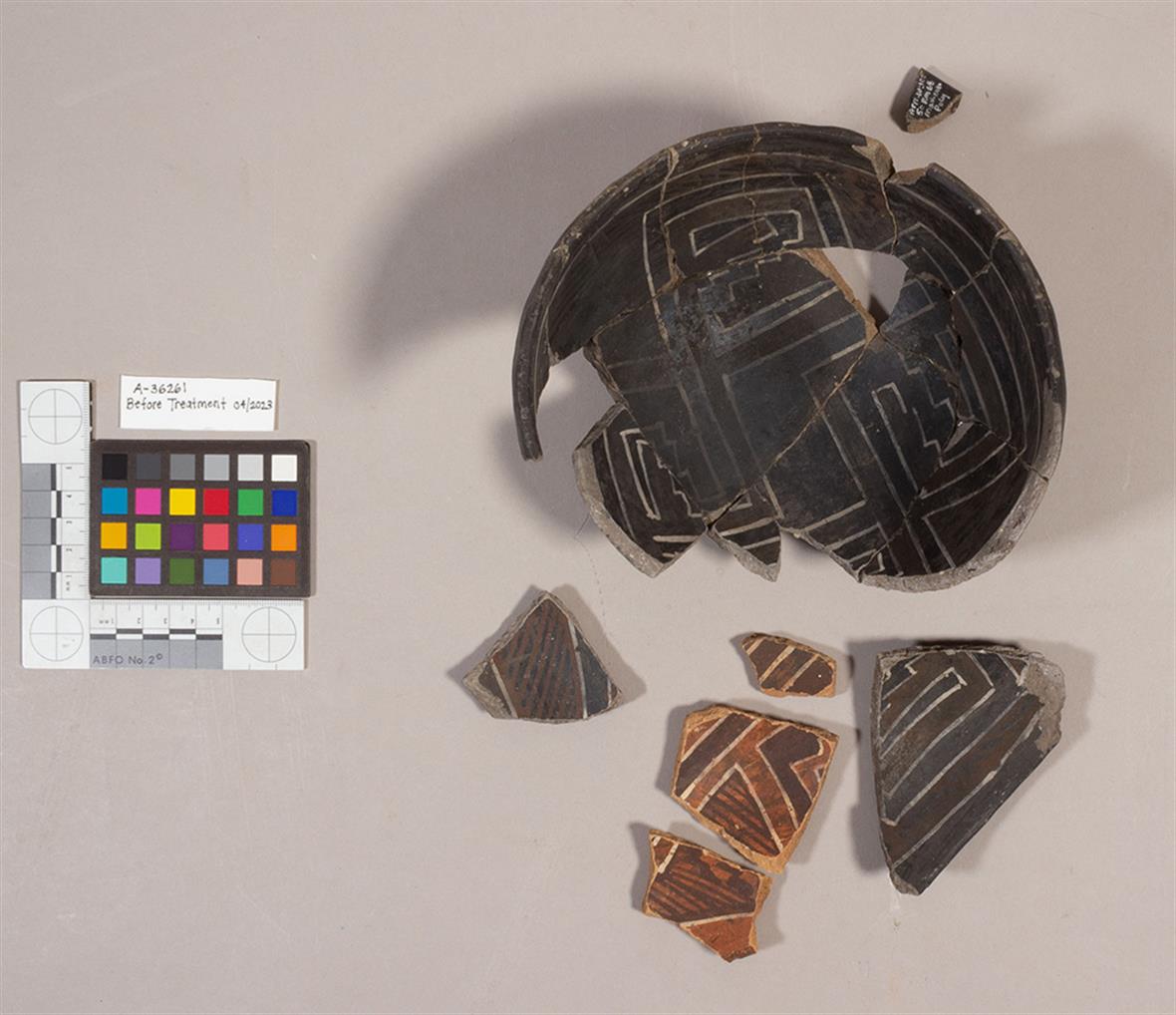 Documentation image (with color and scale measurements) of a broken ceramic; the loose pieces sit nearby.