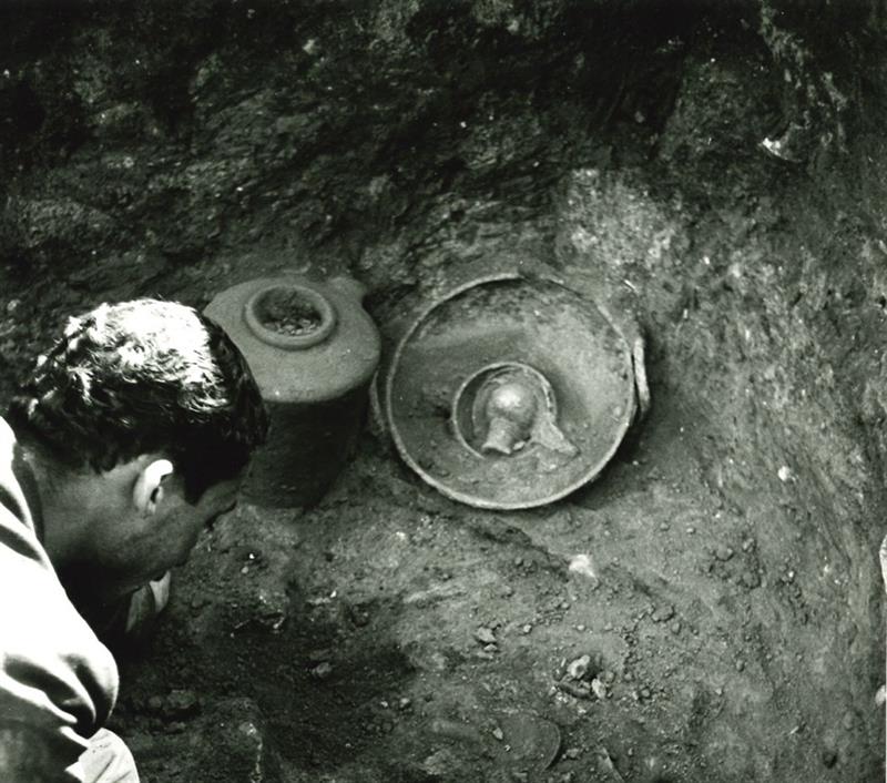 A black and white archival photo of the bronze piece as it was discovered during an archaeological dig.